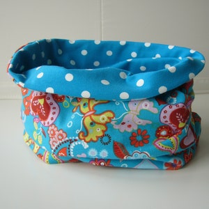 Könnte beinhalten: Ein blauer und weißer Stoff-Halswärmer mit Paisley-Muster und weißen Punkten.