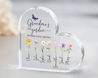 May include: A clear heart-shaped crystal paperweight with the text "Grandma's Garden Where Love Grows" and a butterfly design.  The paperweight features a row of flowers with names written below each flower:  Olivia, John, Sophia, David, Samantha, Sarah, Mary.