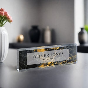 May include: A black and gold marble desk nameplate with the text "Oliver Jones Architect" in white.