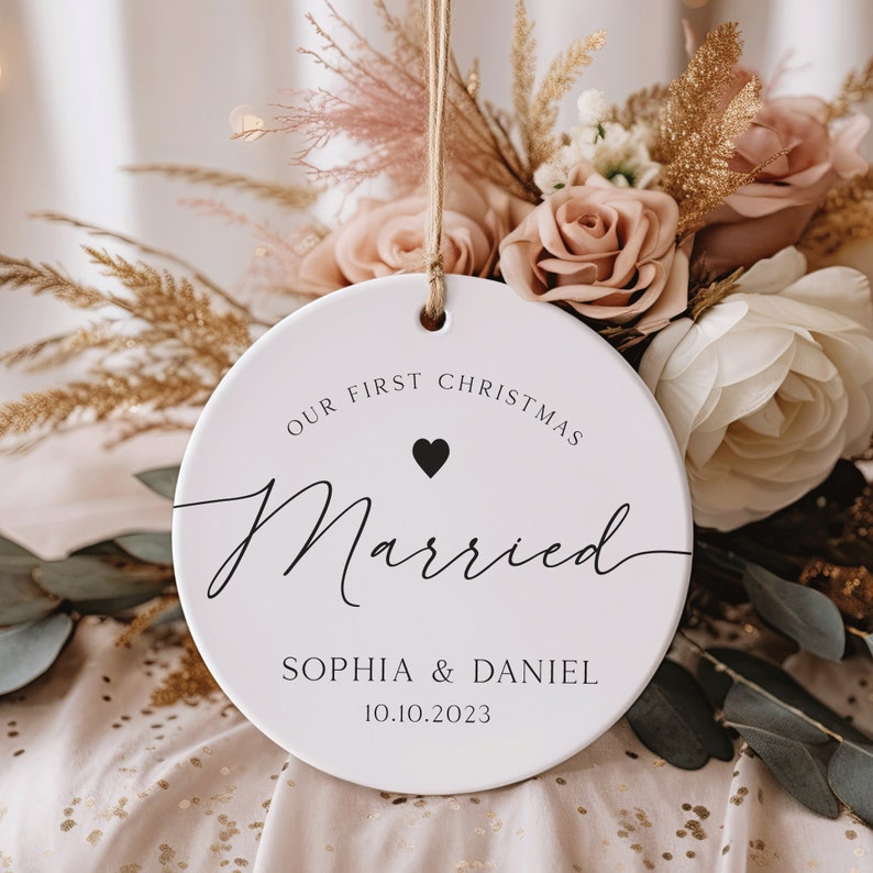May include: White round Christmas bauble with the text "Our First Christmas Married" and the names "Sophia & Daniel" and the date "10.10.2023".