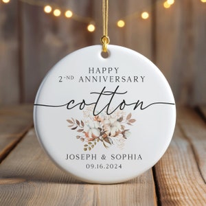 Peut inclure: Ornement en c&eacute;ramique blanche avec un motif floral en coton et le texte "Happy 2nd Anniversary Cotton Joseph & Sophia 09.16.2024".