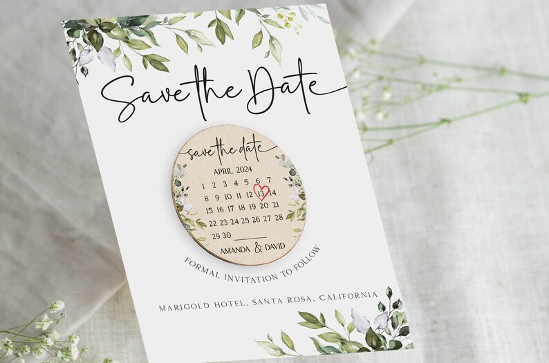 Puede incluir: Tarjeta de guardar la fecha con un c&iacute;rculo de madera que presenta un calendario con un coraz&oacute;n rojo que marca el 13 de abril de 2024. El texto "save the date" est&aacute; escrito en cursiva sobre el calendario. El texto "Amanda & David" est&aacute; escrito debajo del calendario. El texto "Invitaci&oacute;n formal a seguir" est&aacute; escrito debajo del c&iacute;rculo. El texto "Marigold Hotel, Santa Rosa, California" est&aacute; escrito debajo del texto de la invitaci&oacute;n.