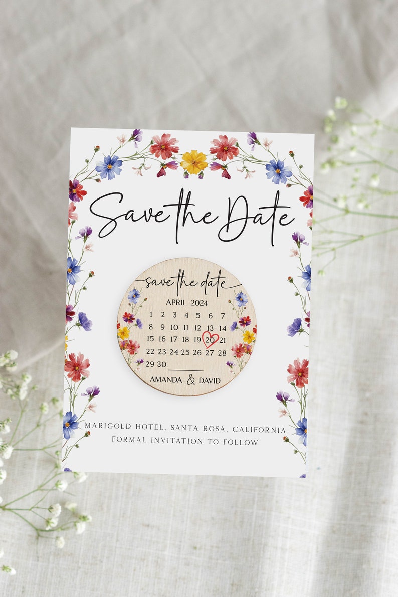 Puede incluir: Tarjeta de guardar la fecha con un borde floral y un c&iacute;rculo de madera con un calendario que muestra abril de 2024 con un coraz&oacute;n sobre el 20. El texto "save the date" est&aacute; escrito en cursiva en el c&iacute;rculo. El texto "Amanda & David" est&aacute; debajo del calendario. El texto "Marigold Hotel, Santa Rosa, California" y "Invitaci&oacute;n formal a seguir" est&aacute; debajo del c&iacute;rculo.