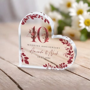 May include: A clear heart-shaped crystal paperweight with a red glitter design. The number 40 is in the center with the text "Wedding Anniversary Amanda & Nick 10.27.1984".