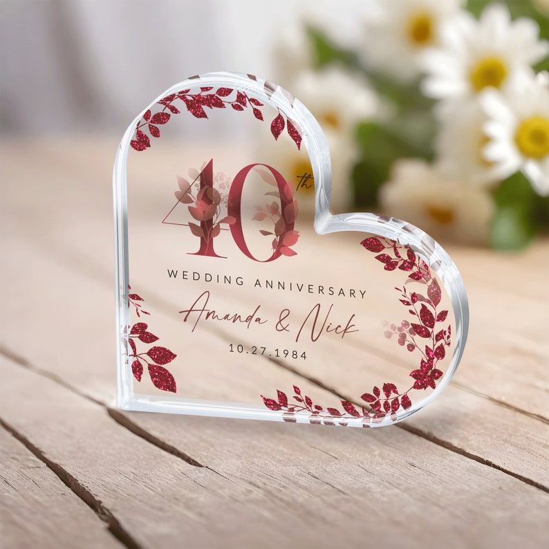 May include: A clear heart-shaped crystal paperweight with a red glitter design. The number 40 is in the center with the text "Wedding Anniversary Amanda & Nick 10.27.1984".