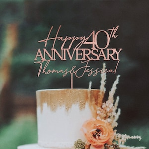 May include: Rose gold cake topper with the text "Happy 40th Anniversary Thomas & Jessica".