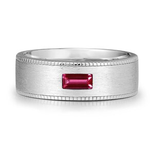 Peut inclure: Une bague en argent avec une pierre précieuse rectangulaire rouge foncé au centre. La bague a une finition en métal brossé et une bordure détaillée. La pierre est un point focal vibrant et accrocheur.