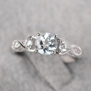 Anello promessa acquamarina intrecciata in argento sterling con taglio rotondo e pietra portafortuna di marzo