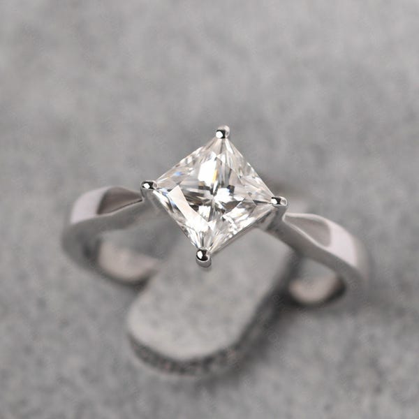 Anillo de compromiso de moissanita con engaste de plata en forma de cometa y diamante simulado de talla princesa.