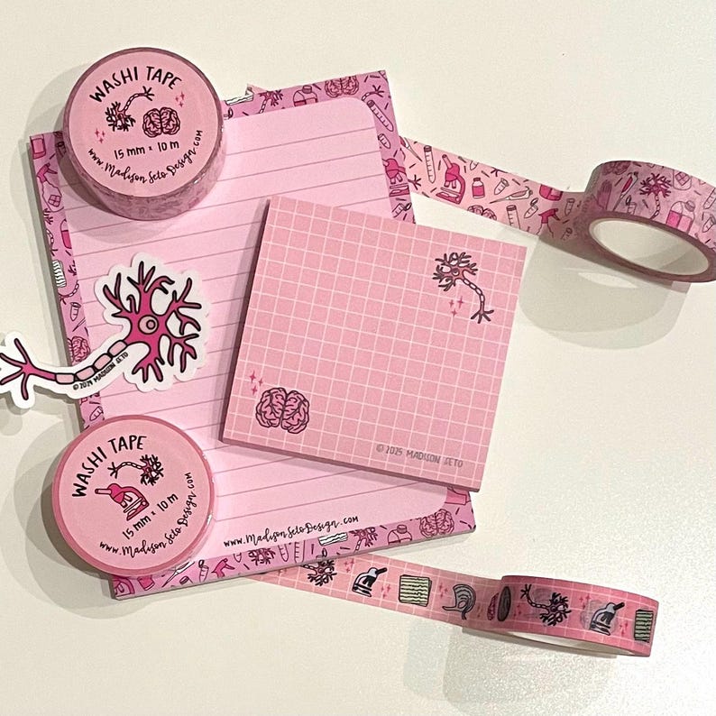 May include: Pink stationery set featuring washi tape, a notepad, and sticky notes. The tape is 15 mm wide and 10 m long. The items are decorated with brain and neuron illustrations. The set includes a sticker with a neuron design.