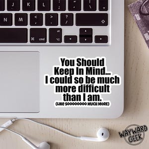 May include: A white sticker on a laptop with the text "You Should Keep In Mind... I could so be much more difficult than I am. (LIKE SOOOOOOOO MUCH MORE)". The Wayward Geek logo is in the bottom right corner.