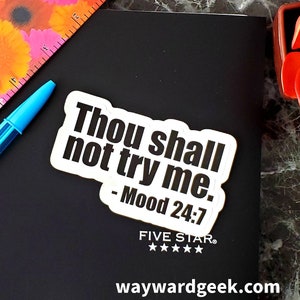 May include: White sticker with black text that reads "Thou shall not try me. - Mood 24:7". The sticker is on a black surface with a five-star rating and the website waywardgeek.com.