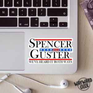 May include: A white sticker with red and blue accents featuring the text "Spencer Guster 2024" and the phrase "We've Heard It Both Ways".