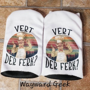 May include: A pair of white ankle socks with a black band at the top. The socks feature a retro-style graphic of a chef with a mustache and the text "Vert Der Ferk?" in black.