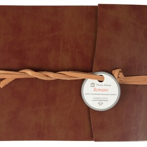 Puede incluir: Un &aacute;lbum de fotos de cuero marr&oacute;n con una correa de cuero beige y una etiqueta que dice "Photo Album Romano Italian Handmade Recycled Leather Handmade in Italy for LEATHERKIND".