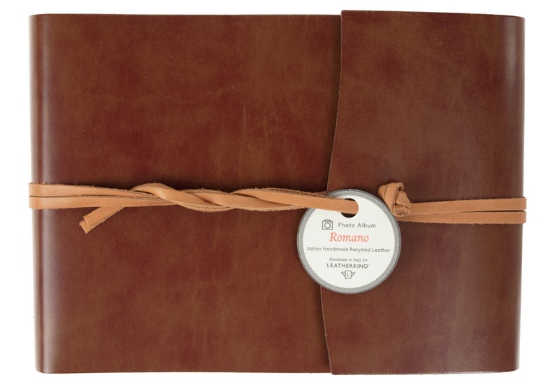Puede incluir: Un &aacute;lbum de fotos de cuero marr&oacute;n con una correa de cuero beige y una etiqueta que dice "Photo Album Romano Italian Handmade Recycled Leather Handmade in Italy for LEATHERKIND".