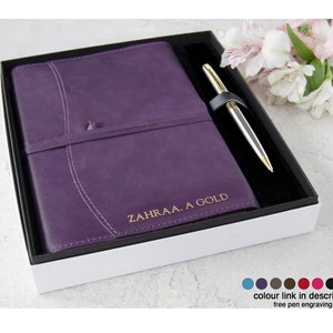May include: A purple leather-bound journal with a gold pen in a white box. The journal is personalized with the name "ZAHRAA. A GOLD".