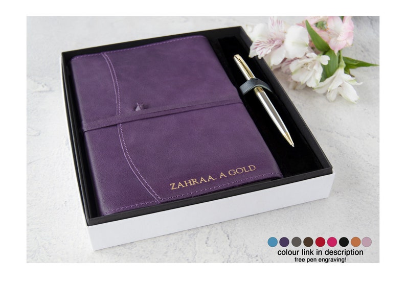 May include: A purple leather-bound journal with a gold pen in a white box. The journal is personalized with the name "ZAHRAA. A GOLD".
