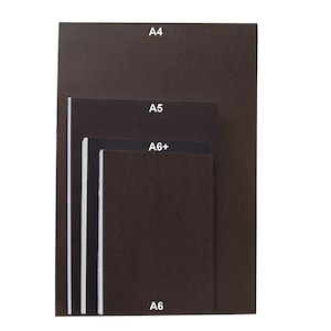 May include: A stack of four dark brown rectangular notebooks or paper sheets arranged in descending order of size. Each item is labeled with white text indicating its size: A4, A5, A6+, and A6. The items have a solid dark brown cover and white edges.