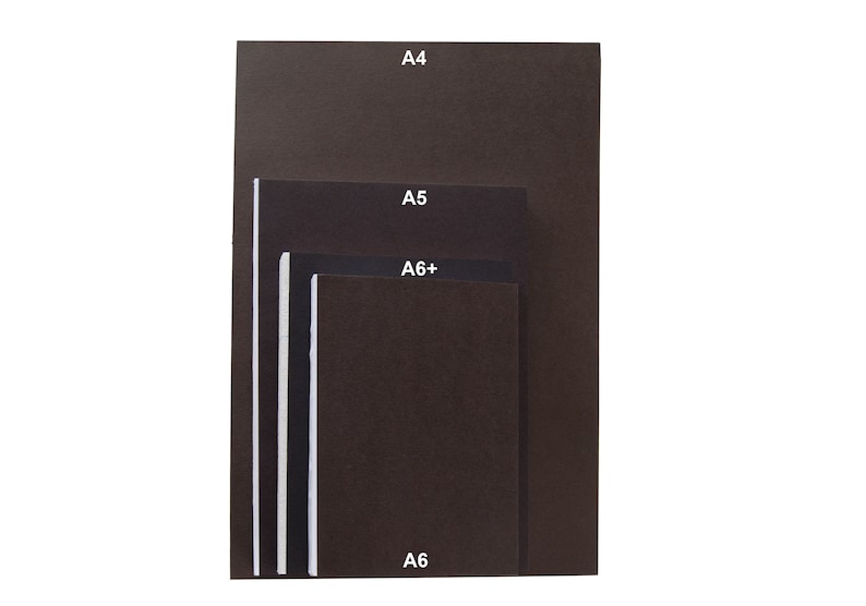May include: A stack of four dark brown rectangular notebooks or paper sheets arranged in descending order of size. Each item is labeled with white text indicating its size: A4, A5, A6+, and A6. The items have a solid dark brown cover and white edges.