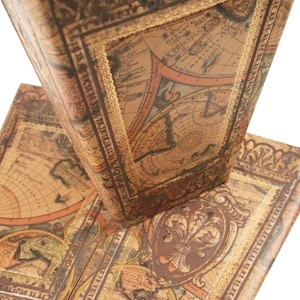 May include: Two vintage-style books with a world map design on the cover. The books are bound in brown leather with gold accents and have a worn, antique look.
