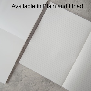 May include: Two white notebooks, one with blank pages and one with lined pages, displayed side by side. The text "Available in Plain and Lined" is printed at the top center of the image, indicating the two different paper styles offered.