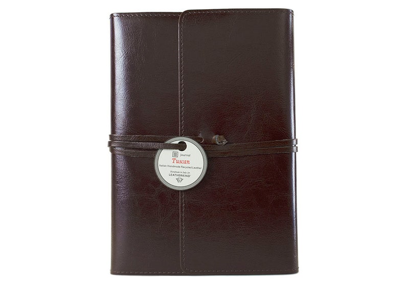 Puede incluir: Un diario de cuero marr&oacute;n con una correa de cuero y una etiqueta que dice "Tuscan Italian Handmade Recycled Leather Journal by Leatherbound".