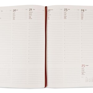 Puede incluir: Cuaderno abierto con p&aacute;ginas rayadas color crema, una cinta roja como marcador y fechas del 19 al 25. Las p&aacute;ginas tienen una cuadr&iacute;cula de l&iacute;neas horizontales para notas. Un peque&ntilde;o calendario es visible en la p&aacute;gina derecha.