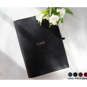 May include: A black leather journal with gold lettering that reads "TAH".