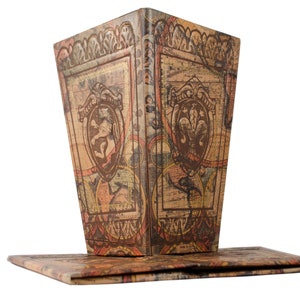 May include: A vintage-style, decorative box with a hinged lid. The box is made of cardboard and features a brown, beige, and orange patterned design with ornate details. The box is closed and the lid is slightly ajar.
