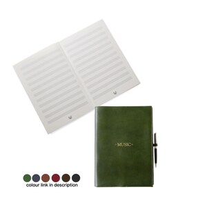 May include: An open music notebook with staff lines and a dark green leather-bound notebook with the word "MUSIC" in gold lettering. A black pen is attached to the side. The notebook is shown with a white background.