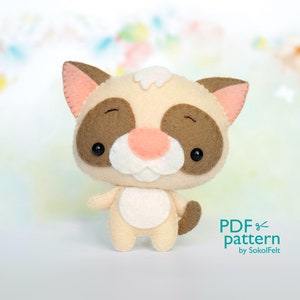 May include: A cute, brown and white felt cat with big eyes and a pink nose. The cat is standing on a white surface. The text "PDF pattern by SokolFelt" is in the bottom right corner of the image.