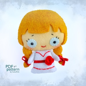 May include: A handmade felt doll with yellow hair and a white dress with red accents. The doll has blue eyes and a red rose on the front. The doll's hair is styled in two pigtails tied with red ribbons. The text "PDF pattern by SokolFelt" is visible.