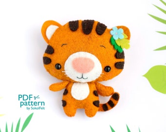 May include: A felt tiger toy with orange and black stripes, a white belly, and a pink nose. The tiger has a blue flower on its head and is looking at the camera.