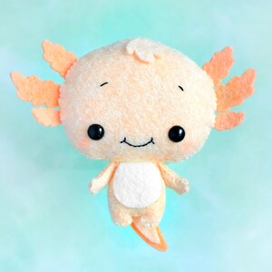 May include: A plush toy axolotl with a light orange body and a white belly. The axolotl has large, black eyes and a small, smiling mouth.