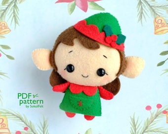 Könnte beinhalten: Eine Filz-Weihnachtswichtelpuppe mit braunen Haaren, einer grünen Mütze mit Stechpalme und einem rot-grünen Kleid. Die Puppe hat ein lächelndes Gesicht mit schwarzen Augen und einer roten Nase.