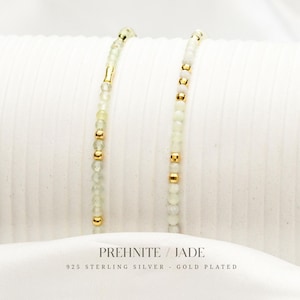 Könnte beinhalten: Zwei zarte Armbänder mit hellgrünem Prehnit und vergoldeten Akzenten. Die Armbänder bestehen aus kleinen, runden Perlen und goldfarbenen Abstandshaltern. Der Text unten lautet "PREHNITE / JADE" und "925 STERLING SILVER - GOLD PLATED."