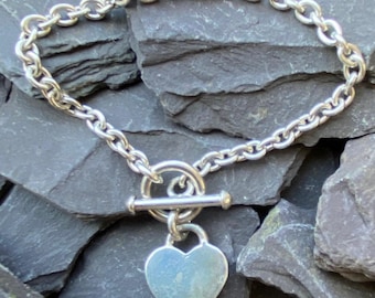 Pulseira em prata de lei com pingente de coração e fecho de alternância.