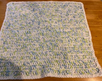 May include: A soft, hand-crocheted blanket in a rectangular shape. The blanket features a textured pattern with horizontal stripes of white, light blue, and green yarn. The edges are finished with a white border.