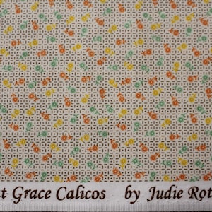May include: Cream-coloured fabric featuring a floral pattern in orange, yellow, and green. The design includes a grid pattern with small flowers. The text "Aunt Grace Calicos by Judie Rothermel" is printed along the bottom edge.