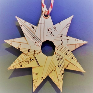 small stars made of music paper, hand-folded, nine points, eyelet for hanging, Christmas