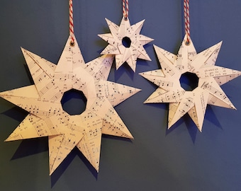 all three sizes of the stars made of music paper, hand-folded, nine points, loop for hanging, Christmas