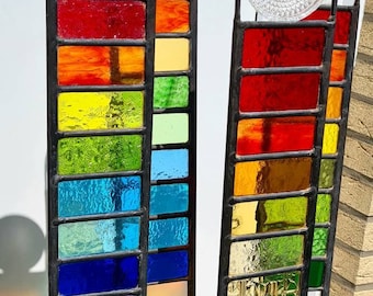 Tuinstenen van gebrandschilderd glas met een vintage element (oude glazen onderzetter) zorgen voor prachtige lichtreflecties.