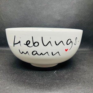 Könnte beinhalten: Weiße Keramikschüssel mit schwarzer Aufschrift "lieblings mann" und einem kleinen roten Herz.