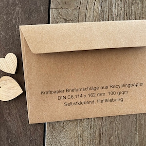 Op de afbeelding: Bruine papieren envelop met een zelfklevende sluiting. De envelop is gemaakt van gerecycled papier en is geschikt voor standaard brievenpost. De tekst op de envelop luidt: "Kraftpapier Briefumschl&auml;ge aus Recyclingpapier DIN C6, 114 x 162 mm, 100 g/qm Selbstklebend, Haftklebung"