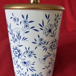 Peut inclure: Une boîte en céramique blanche avec un couvercle doré et un motif floral bleu et blanc.