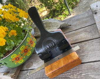 Antique Leitz hole punch, series 180, heavy cast iron hole punch screwed onto a wooden base, antique office furniture from the 1920s.