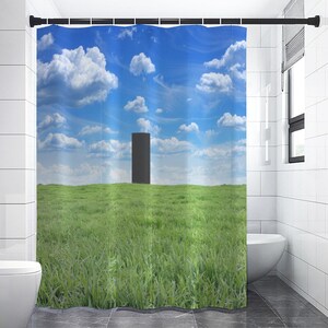 May include: A black shower curtain with a minimalist design featuring a single black rectangle in a field of green grass against a blue sky with white clouds.
