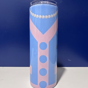 Può includere: Un bicchiere azzurro con un design rosa a forma di maglione. Il design include una collana di perle, uno scollo a V e quattro grandi cerchi. Il bicchiere è cilindrico e ha un coperchio trasparente.