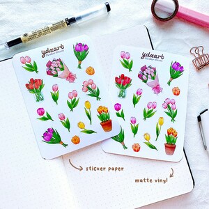 Op de afbeelding: Twee sticker vellen met illustraties van kleurrijke tulpen. De stickers bevatten boeketten, pot tulpen en individuele bloemen in roze, paars, rood en geel. De tekst "ydxart Sticker Sheets" is zichtbaar.